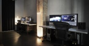 Dunkler Filmschnittplatz mit Monitoren und leerem Drehstuhl